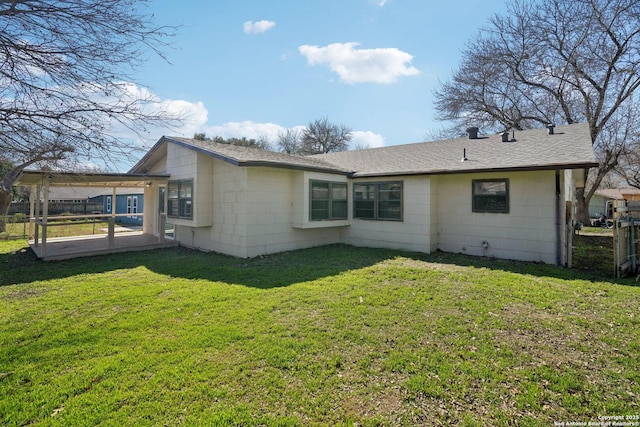 rear view of property with a patio and a lawn