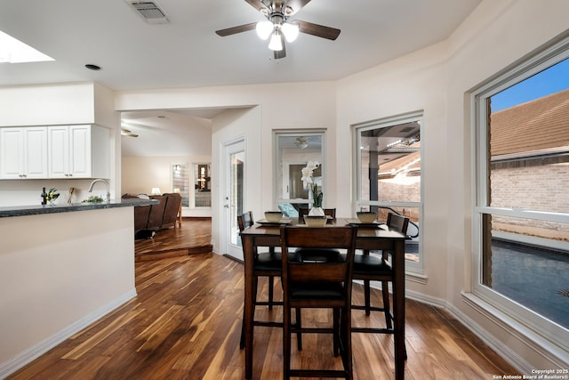 dining area with ceiling fan, sink, and dark hardwood / wood-style flooring