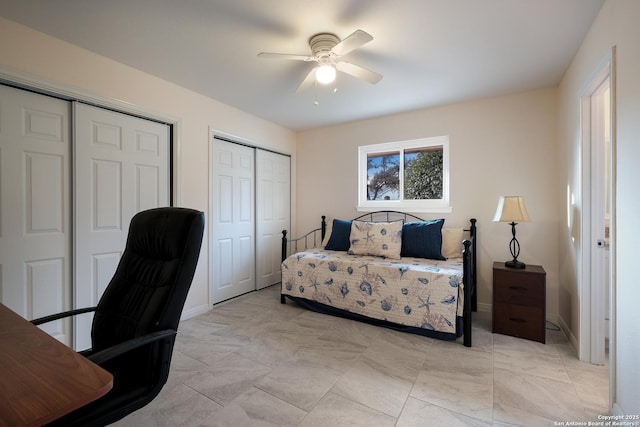 bedroom with ceiling fan and multiple closets