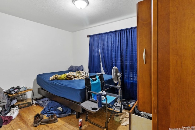 bedroom featuring a textured ceiling and hardwood / wood-style floors