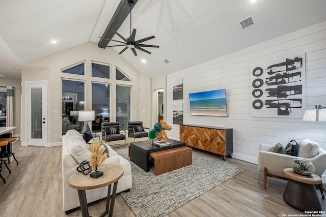 living room featuring light wood-type flooring, high vaulted ceiling, ceiling fan, and beam ceiling