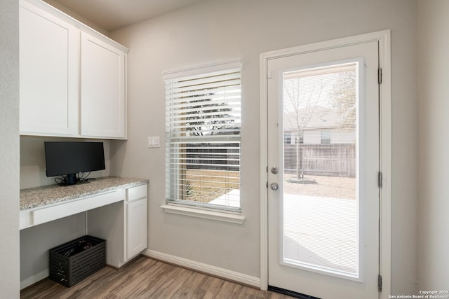 entryway with light wood-type flooring and built in desk