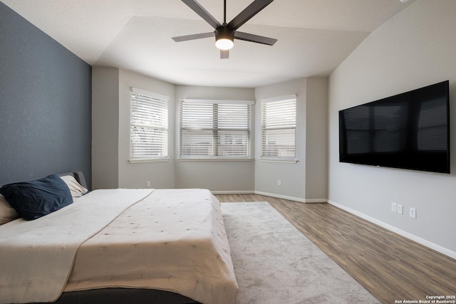 bedroom with multiple windows, ceiling fan, and wood-type flooring