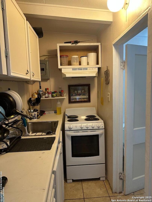 kitchen featuring white electric range, sink, white cabinetry, and light tile patterned flooring