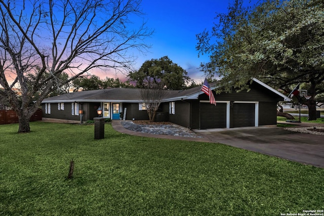 ranch-style home with a garage and a lawn