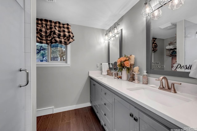 bathroom featuring hardwood / wood-style flooring, vanity, and walk in shower