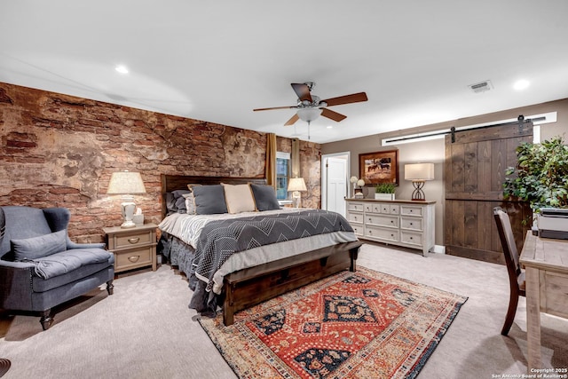 carpeted bedroom featuring ceiling fan and a barn door