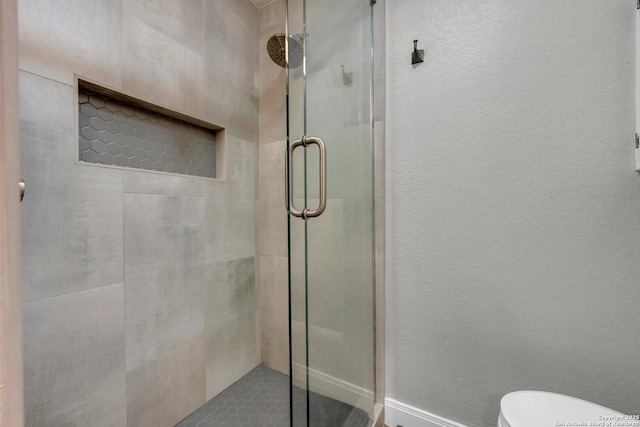 bathroom featuring an enclosed shower and toilet