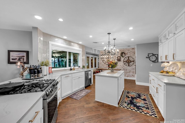 kitchen with appliances with stainless steel finishes, a center island, white cabinetry, decorative light fixtures, and dark hardwood / wood-style flooring