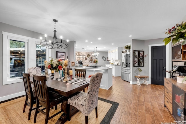 dining room with a notable chandelier, light wood-type flooring, and wine cooler