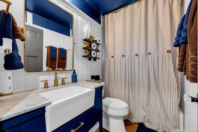 bathroom featuring toilet, vanity, walk in shower, and hardwood / wood-style floors