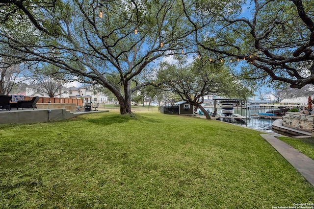 view of yard featuring a water view and a boat dock