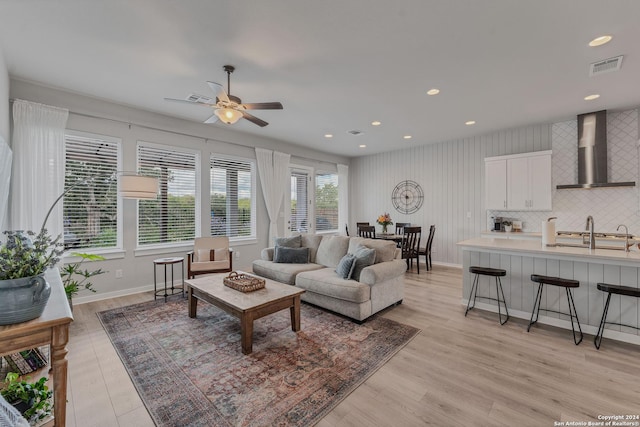 living room with ceiling fan, light hardwood / wood-style flooring, and sink