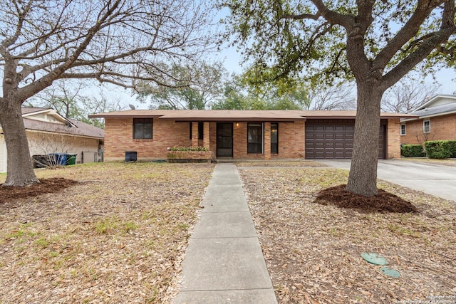 view of front of property featuring concrete driveway, brick siding, and an attached garage