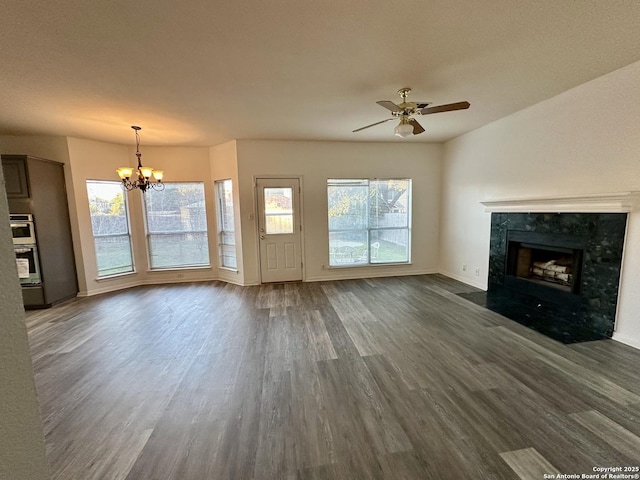 unfurnished living room featuring a fireplace, dark hardwood / wood-style flooring, and ceiling fan with notable chandelier