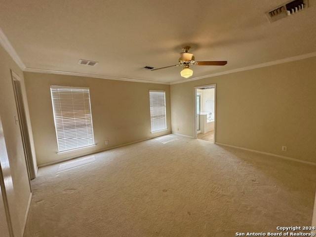 carpeted spare room with crown molding and ceiling fan