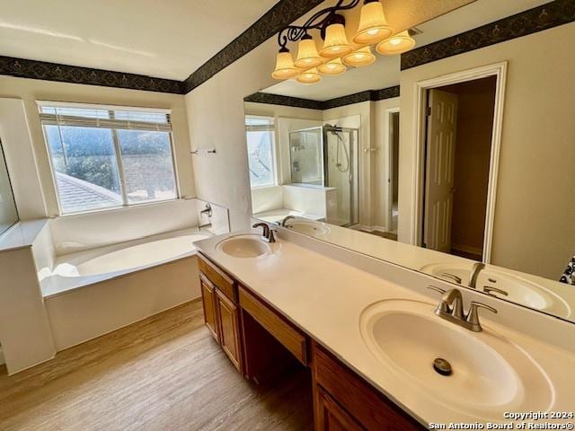 bathroom with wood-type flooring, independent shower and bath, and vanity