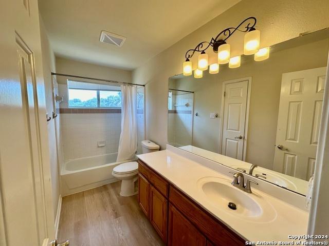 full bathroom featuring vanity, toilet, shower / bath combo, and hardwood / wood-style floors