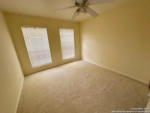 carpeted spare room with ceiling fan