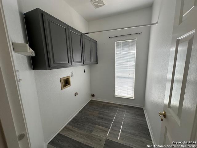 laundry room featuring cabinets, hookup for an electric dryer, hookup for a washing machine, and dark hardwood / wood-style floors