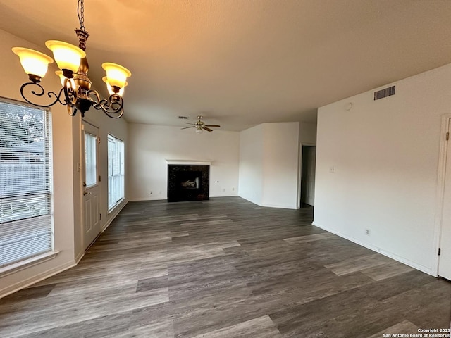 unfurnished living room with ceiling fan with notable chandelier and dark hardwood / wood-style floors