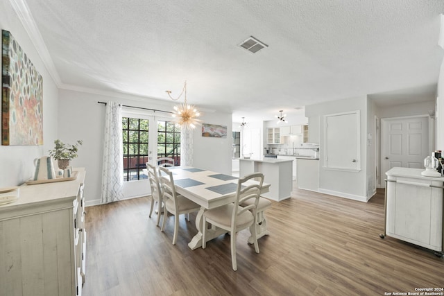 dining space featuring hardwood / wood-style floors, an inviting chandelier, french doors, and a textured ceiling