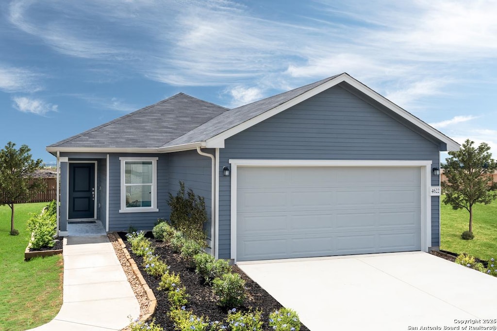 single story home featuring a garage and a front lawn