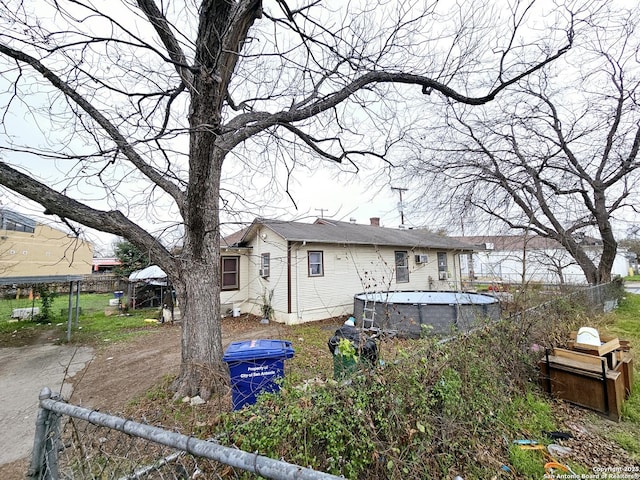 rear view of house featuring a fenced in pool