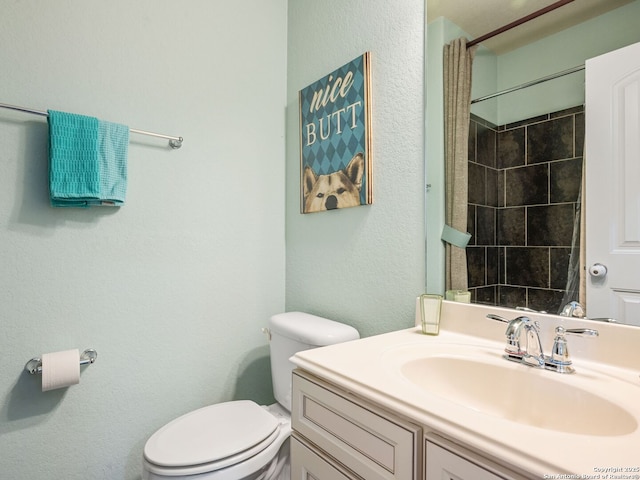 bathroom featuring toilet, vanity, and walk in shower