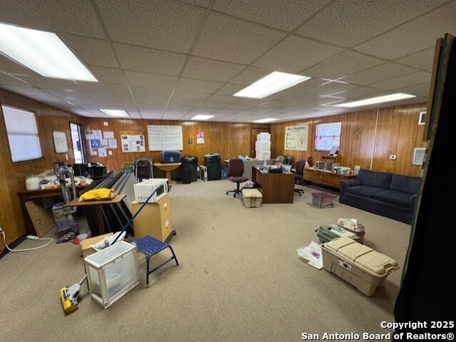 miscellaneous room with a drop ceiling, wood walls, and carpet floors