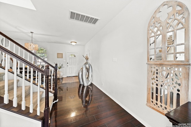 stairs with an inviting chandelier and hardwood / wood-style floors