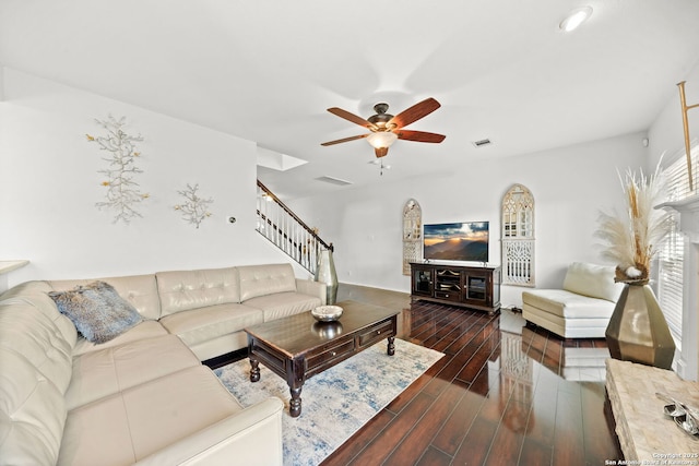 living room featuring dark wood-type flooring and ceiling fan