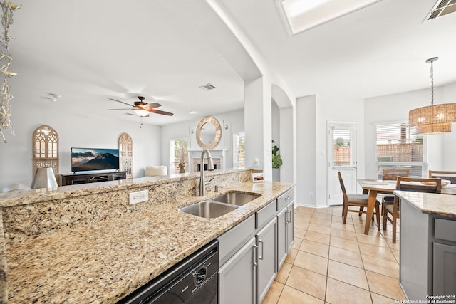 kitchen with gray cabinetry, decorative light fixtures, sink, light stone counters, and light tile patterned floors