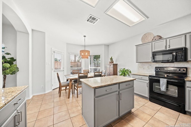 kitchen with a kitchen island, black appliances, gray cabinetry, and decorative light fixtures