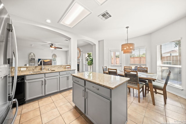 kitchen featuring gray cabinets, pendant lighting, sink, and a kitchen island