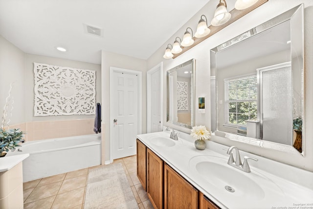 bathroom with tile patterned floors, a tub, and vanity