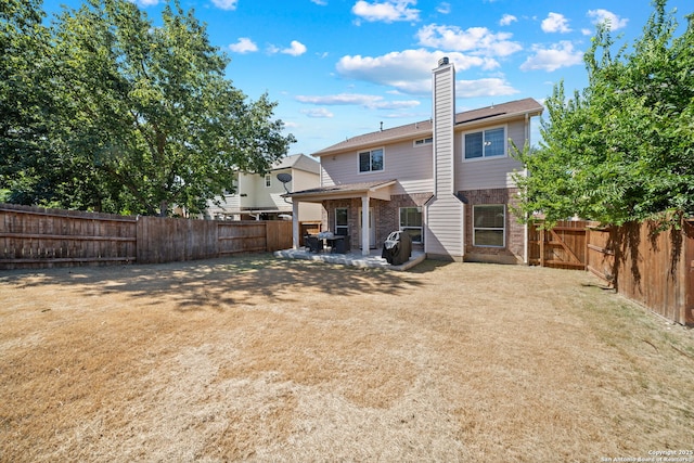 rear view of house featuring a patio area and a yard