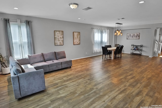 living room with a notable chandelier and dark hardwood / wood-style floors