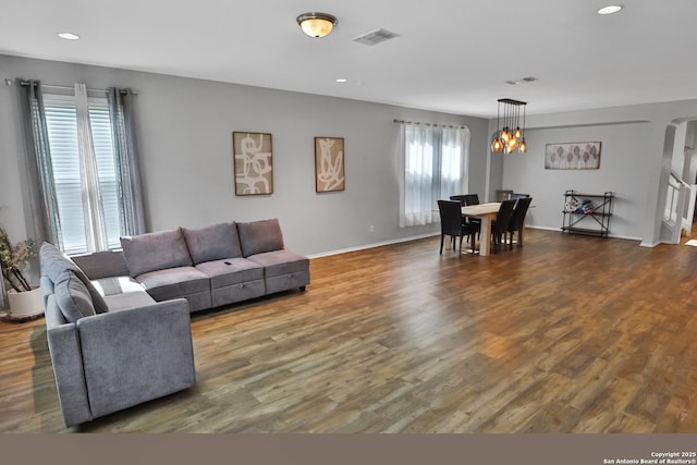 living room featuring dark wood-type flooring and an inviting chandelier