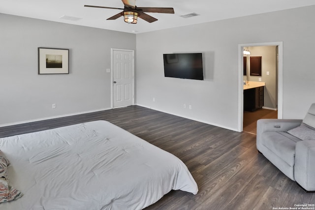 bedroom featuring ceiling fan, ensuite bath, and dark hardwood / wood-style flooring