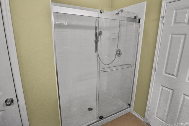 bathroom featuring tile patterned flooring and an enclosed shower