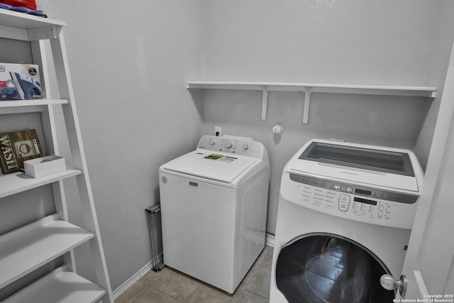 clothes washing area featuring washer and dryer and light tile patterned floors