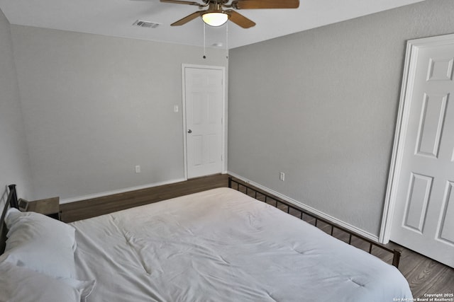 bedroom with ceiling fan and dark hardwood / wood-style floors