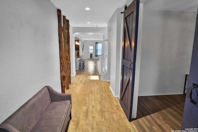 hallway featuring light hardwood / wood-style floors and a barn door