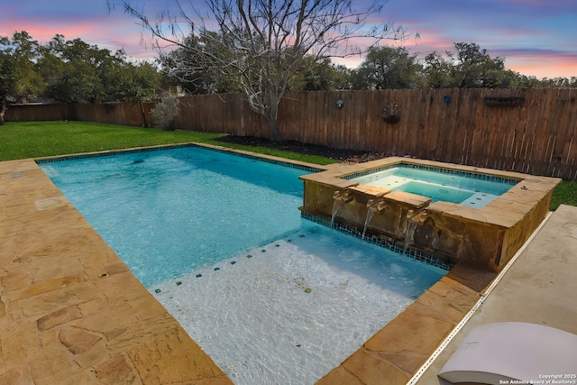 pool at dusk featuring a yard and an in ground hot tub