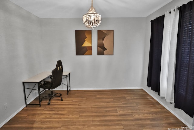 office with hardwood / wood-style flooring and an inviting chandelier