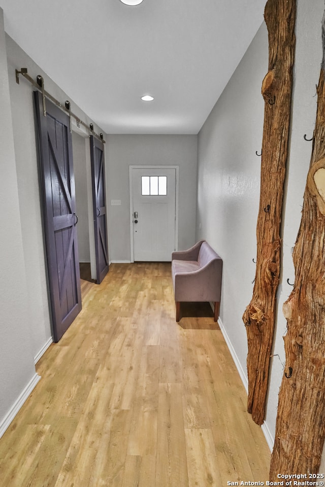 entryway featuring light wood-type flooring and a barn door