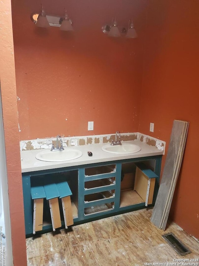 interior details featuring visible vents, a sink, and wood finished floors