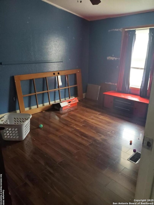 empty room featuring visible vents, wood finished floors, and a ceiling fan