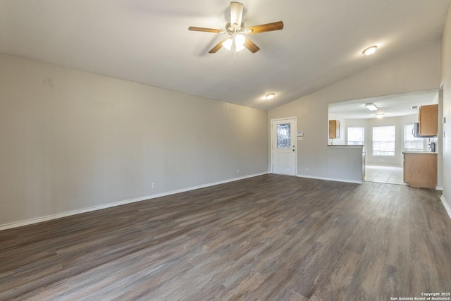 unfurnished living room featuring ceiling fan, vaulted ceiling, and dark hardwood / wood-style flooring